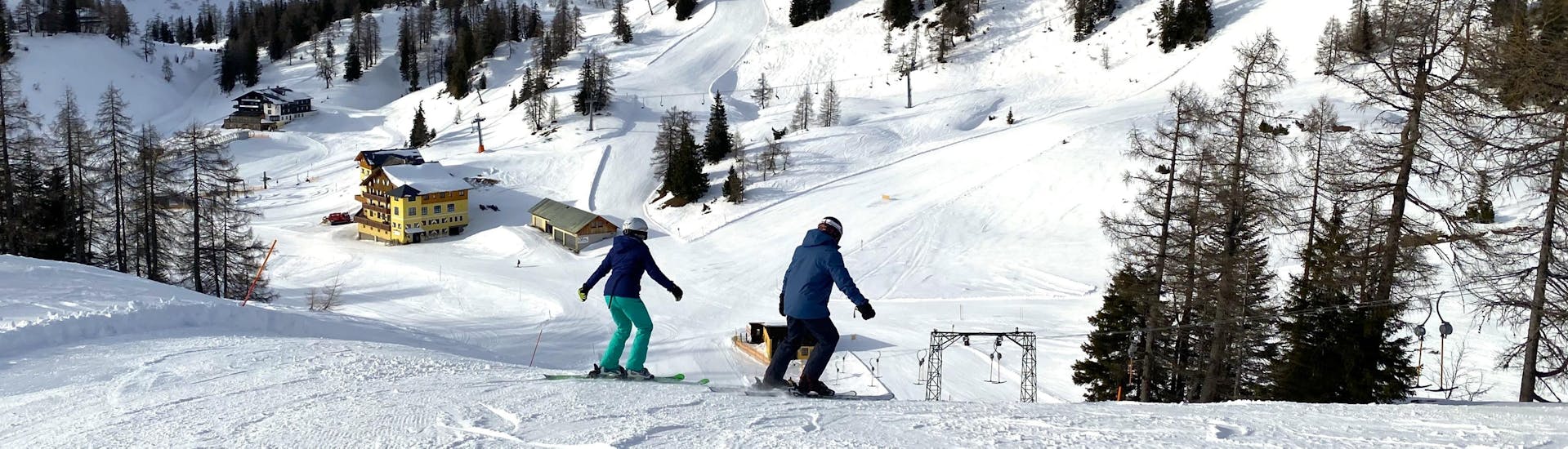 Zwei Teilnehmer genießen eine Abfahrt am Schnee in Tauplitz in einem Kurs von Gipfelmomente Tauplitz.