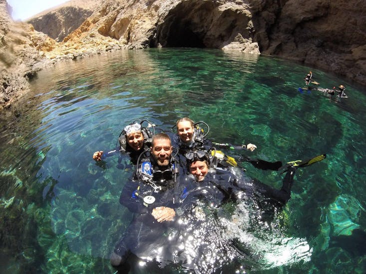 3 participants with their diving instructor in the water during a dive in Mykonos with GoDive Mykonos.