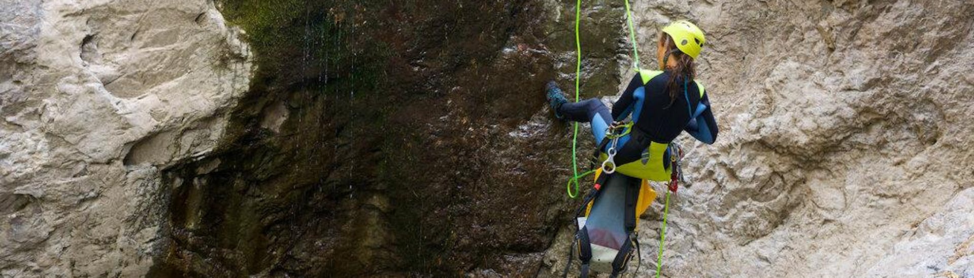 A woman descending a canyon during a full-day canyoning activity.