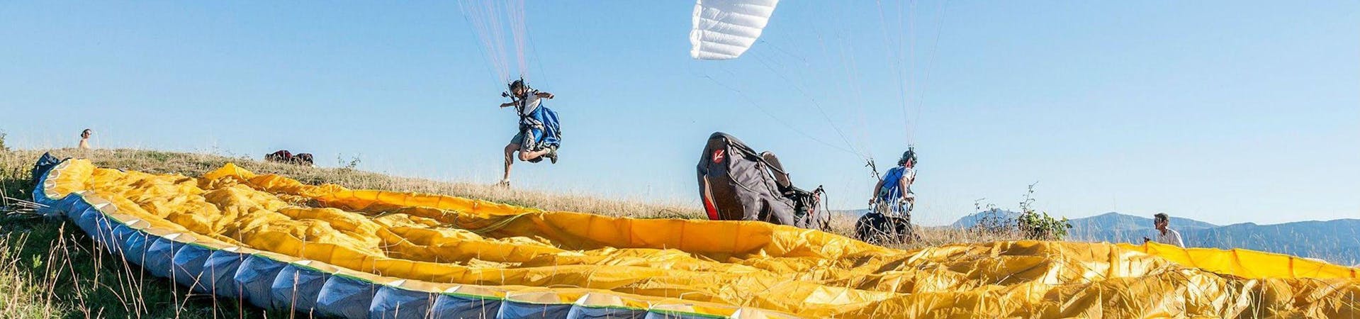 Two persons are participating to the Paragliding activity with Haut Les Mains.