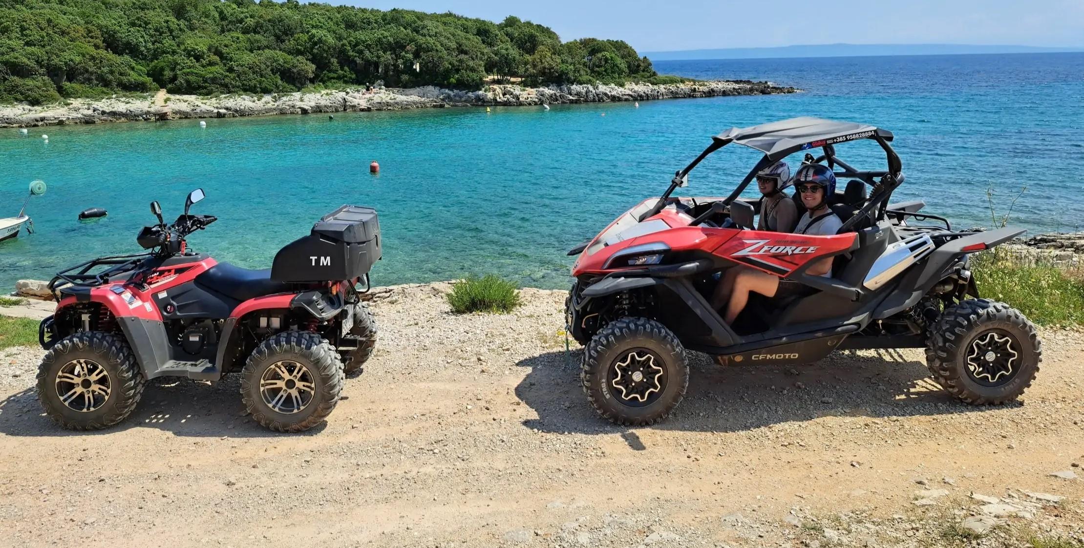 Una coppia davanti al mare con il passeggino del Globus Quad Safari Medulin e un Quad davanti a loro.