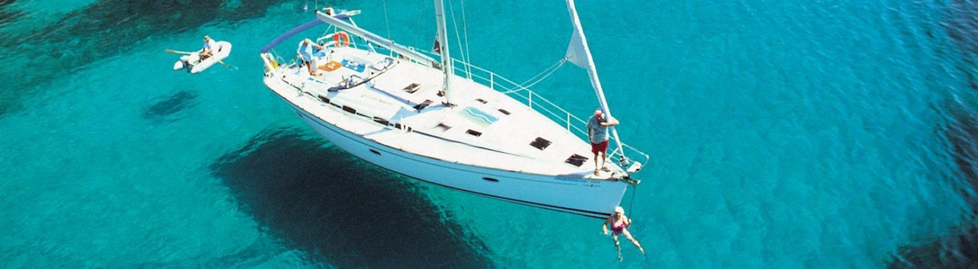 Un elegante velero sobre las aguas turquesas del Mar Egeo durante un viaje en velero a Delos y Rinia con Set Sail Mykonos.