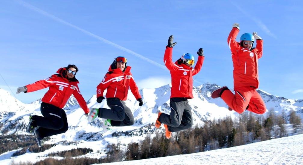 Some instructors from Scuola di Sci Pila jumping on a slope in front of the camera.