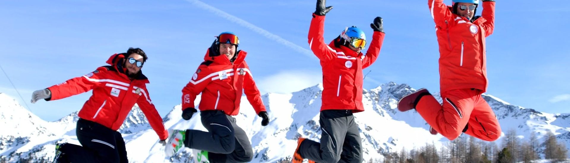 Some instructors from Scuola di Sci Pila jumping on a slope in front of the camera.