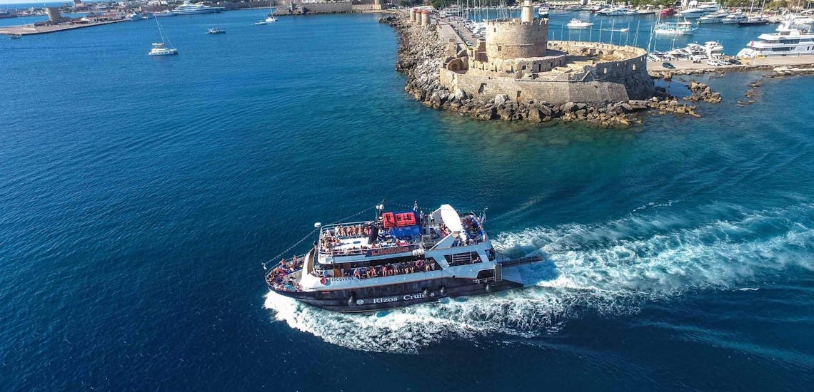 The boat "Discovery" is navigating along the coast during one of the boat trips with Rizos Cruises Rhodes.