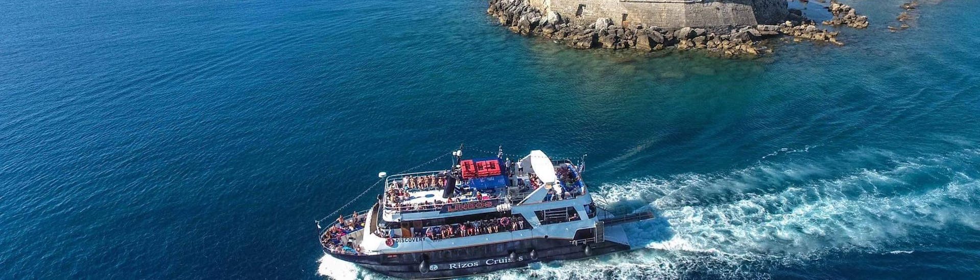 The boat "Discovery" is navigating along the coast during one of the boat trips with Rizos Cruises Rhodes.
