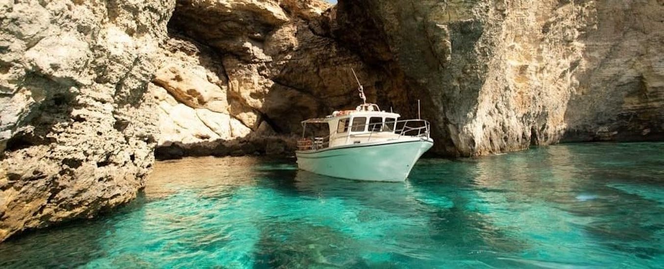 A boat sails out of the comino caves during a Boat Trip organized by Aloha Boat Charters Malta.