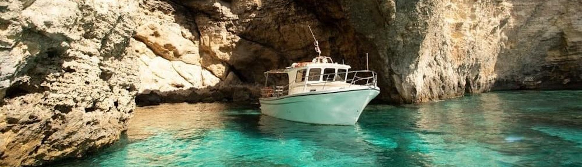 Ein Boot fährt aus den Comino Höhlen während einer Bootstour organisiert von Aloha Boat Charters Malta.