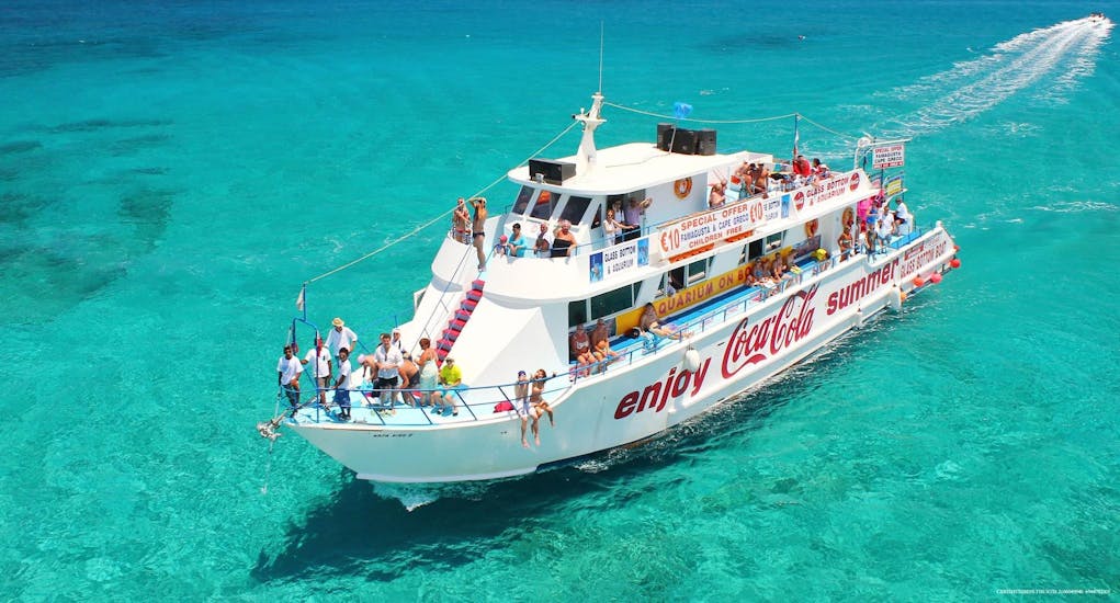 Protaras Boat Excursion's Coca-Cola boat navigates through crystal-clear waters during a trip.