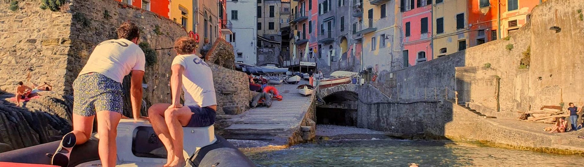 Dos patrones en una lancha RIB de HopHop Boat La Spezia acercándose a uno de los pueblos de Cinque Terre.