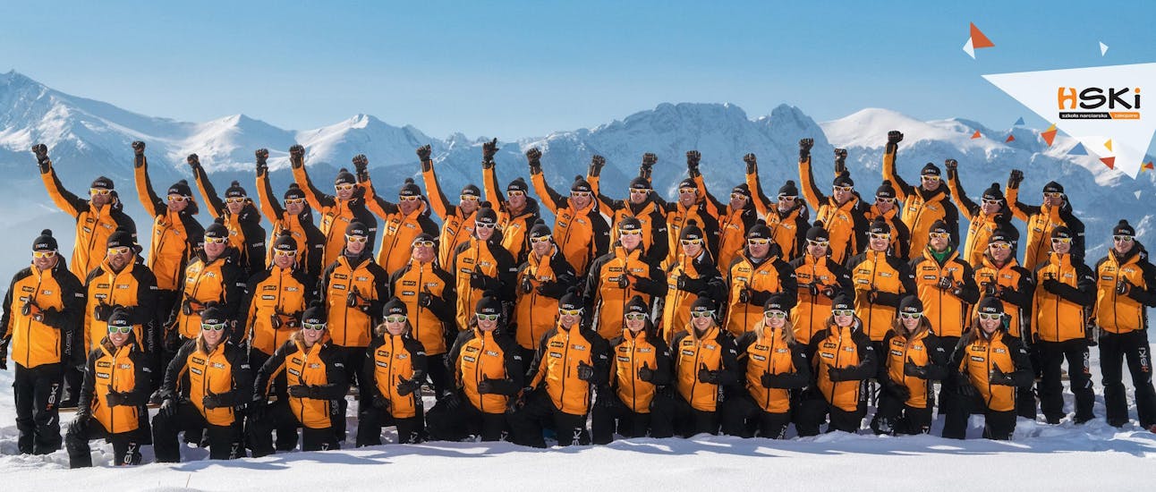 Das gesamte HSKI-Team posiert für ein Gruppenfoto mit der Skischule HSKI Zakopane.