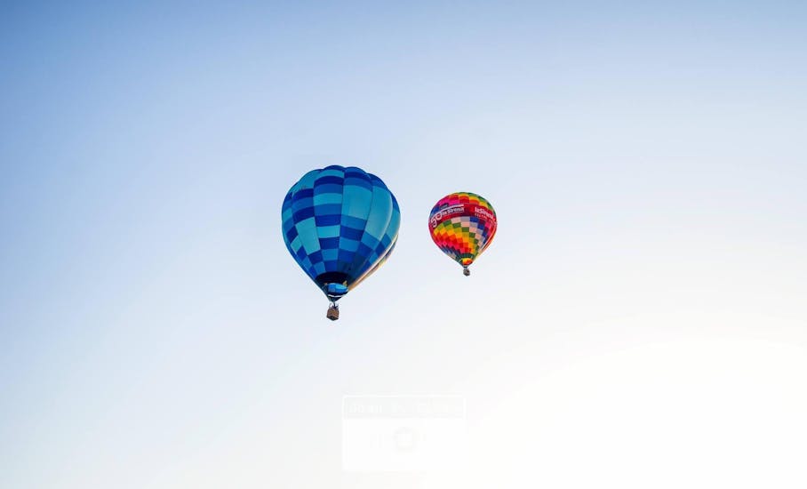 Two hot air balloons from Ibiza en Globo float several metres in the sky.