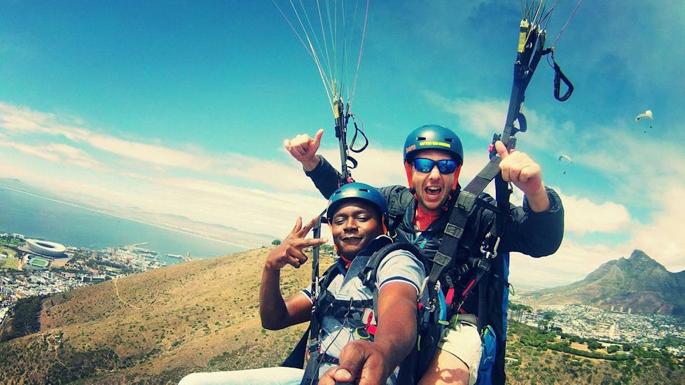 A pilot from Icarus Tandem Paragliding is flying a tourist over Cape Town.