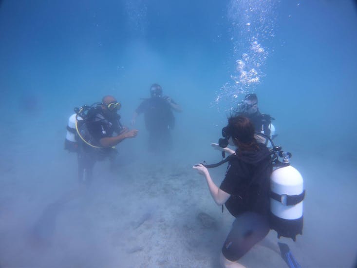 Four people learning skills underwater during a course of Just Dive Croatia. 