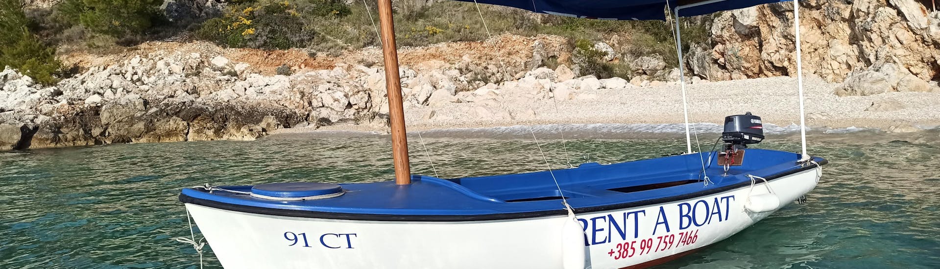 Side perspective of a Elan Pasara 490 boat from Cavtat Rent a boat, anchored in clear blue waters.