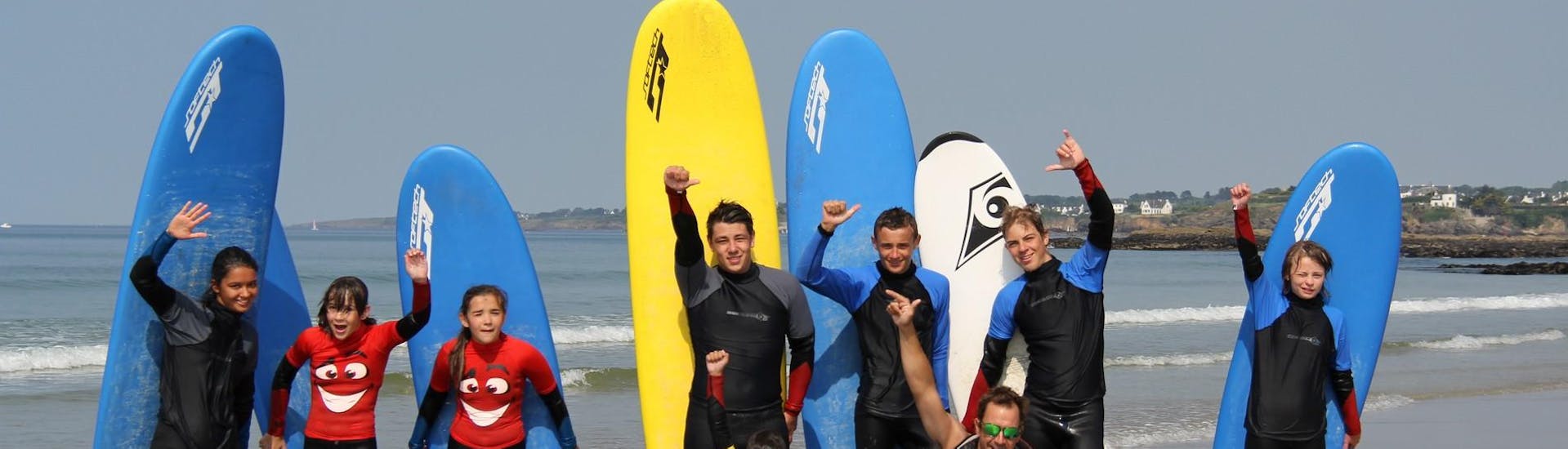 A group of kids posing with their boards for the photo with YouSurf in Guidel-Plage.