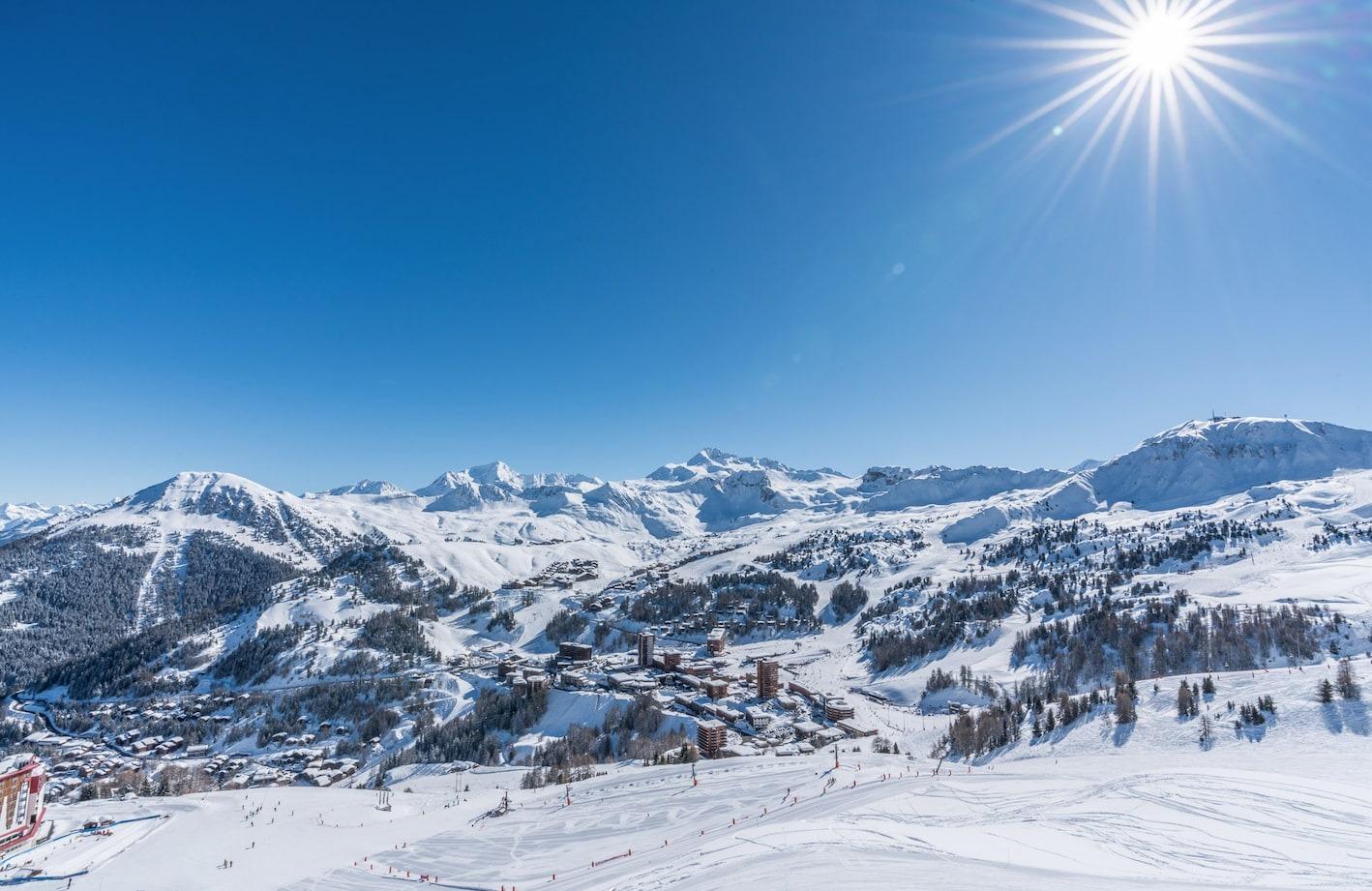 Het dal van de skischool Oxygène La Plagne onder de zon.