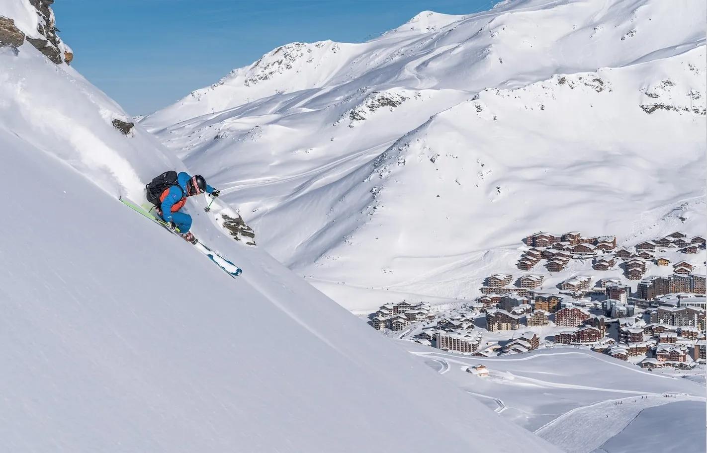 Uno de los instructores de la escuela de esquí Oxygene bajando por una pista de la estación de Val Thorens con el valle a lo lejos.