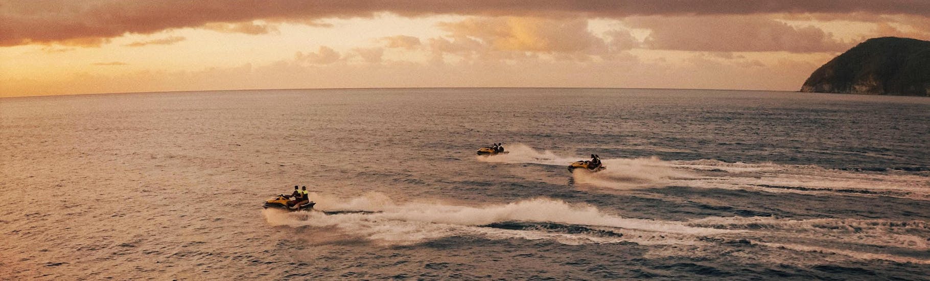 A group of several people on 3 Jet skis have fun during the jet ski safari in the Cousteau reserve with Iron Jet Bouillante.