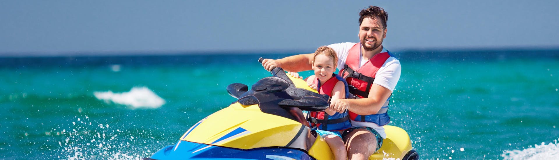 Father and daughter are having fun on a jetski
