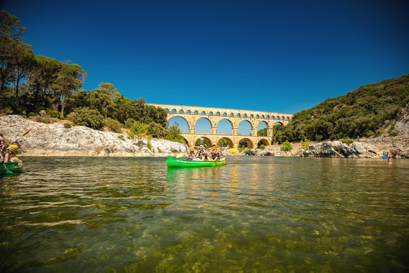 Thanks to Kayak Vert, a family is spending a good day paddling on the Gardon with the Pont du Gard in the background, one of the most popular canoeing destinations in France.