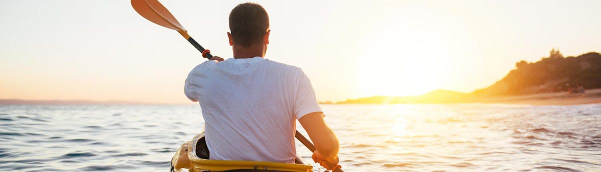 Kayak au coucher du soleil SEM Hero Homme dans son kayak lors d'une activité de kayak au coucher du soleil.