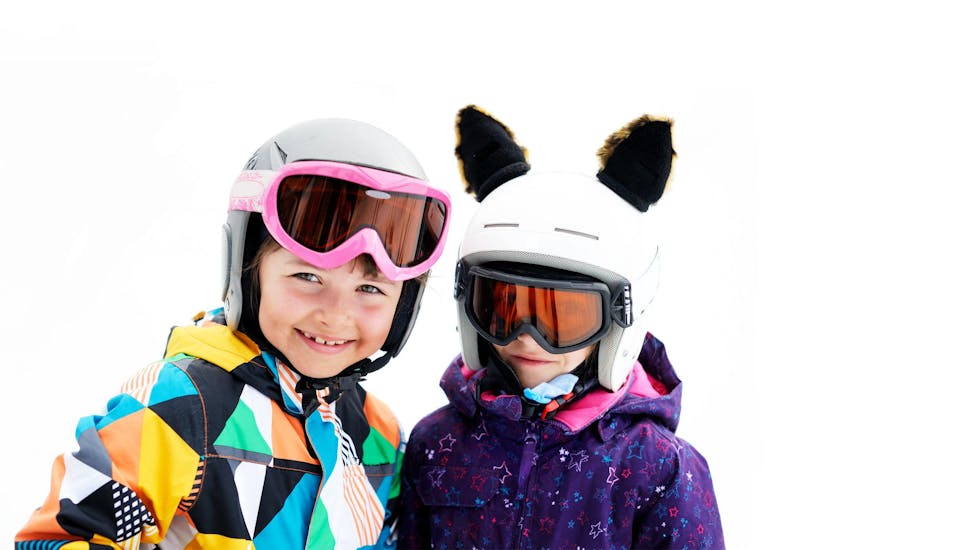 Two young children smiling at the camera during one of the Private Ski Lessons for Kids organised by ESI Snow Diam's Espace Diamant.