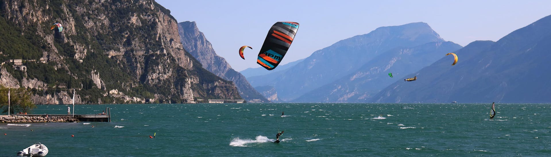 A young woman surfing in the clear blue waters of the surfing and SUP hotspot of Lake Garda.