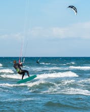 A young man sliding on the wave in Fehmarn while windsurfing.
