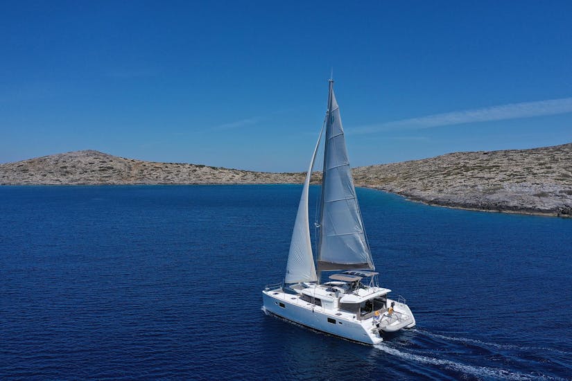A catamaran on the beautiful and crystal clear Greece sea on a cruise from DanEri Yachts Crete