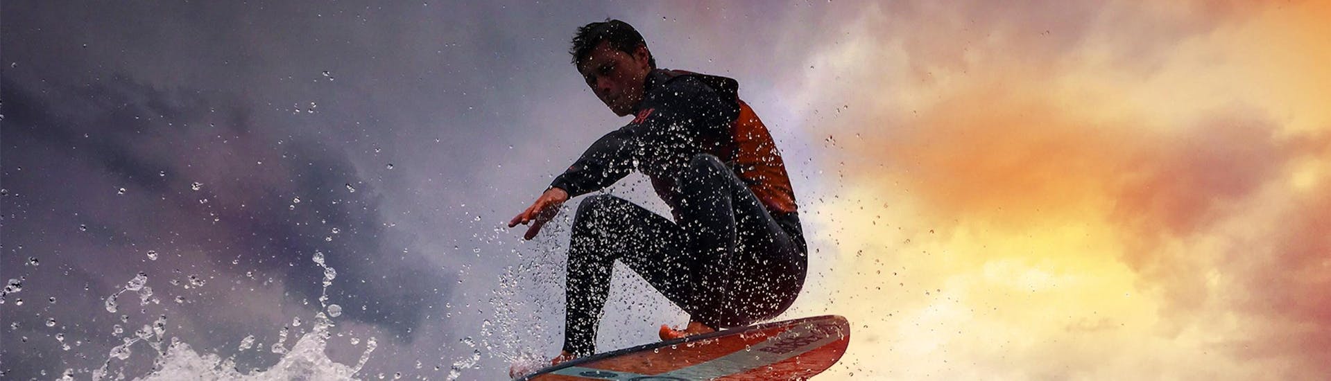 A man is surfing on a wave thanks to Le Spot which offers waterskiing lessons, wakesurfing lessons and wakeboarding lessons on Lake Annecy.