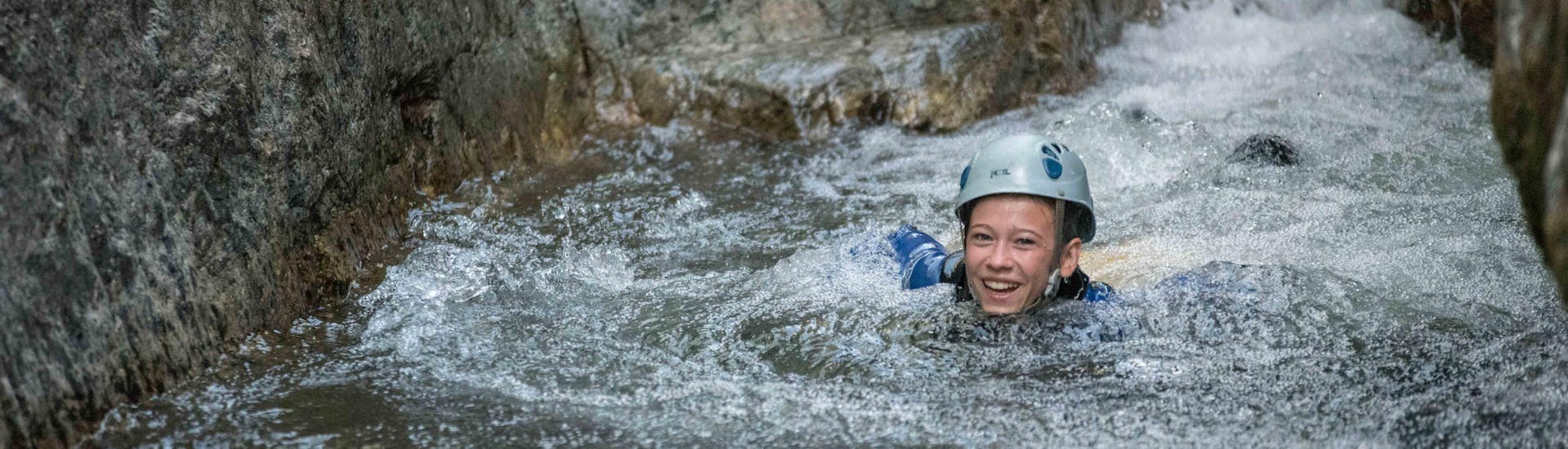 A canyoning enthusiast is swimming in a natural pool during a canyoning tour with Les Intraterrestres.