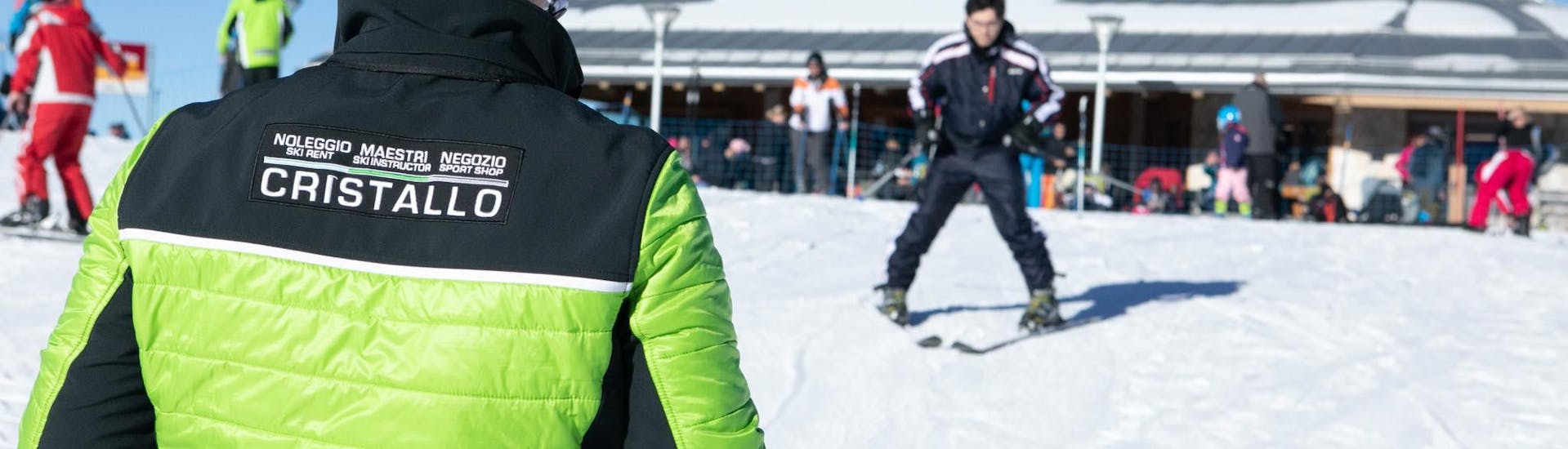 A instructor of Maestri di Sci e Snowboard Cristallo - Monte Bondone is looking at a participant in the ski lessons in the ski resort of Monte Bondone.