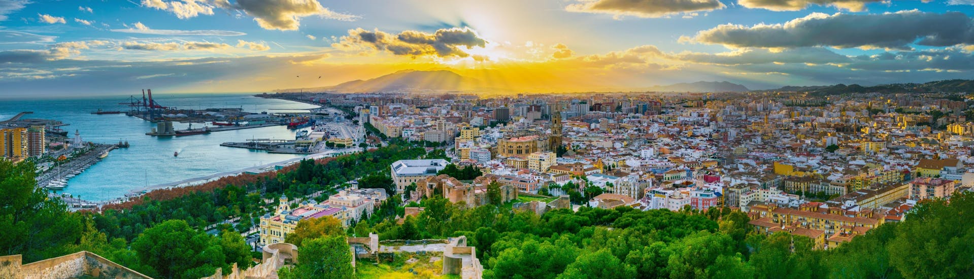 The city of Malaga at sunset with the port in the background.