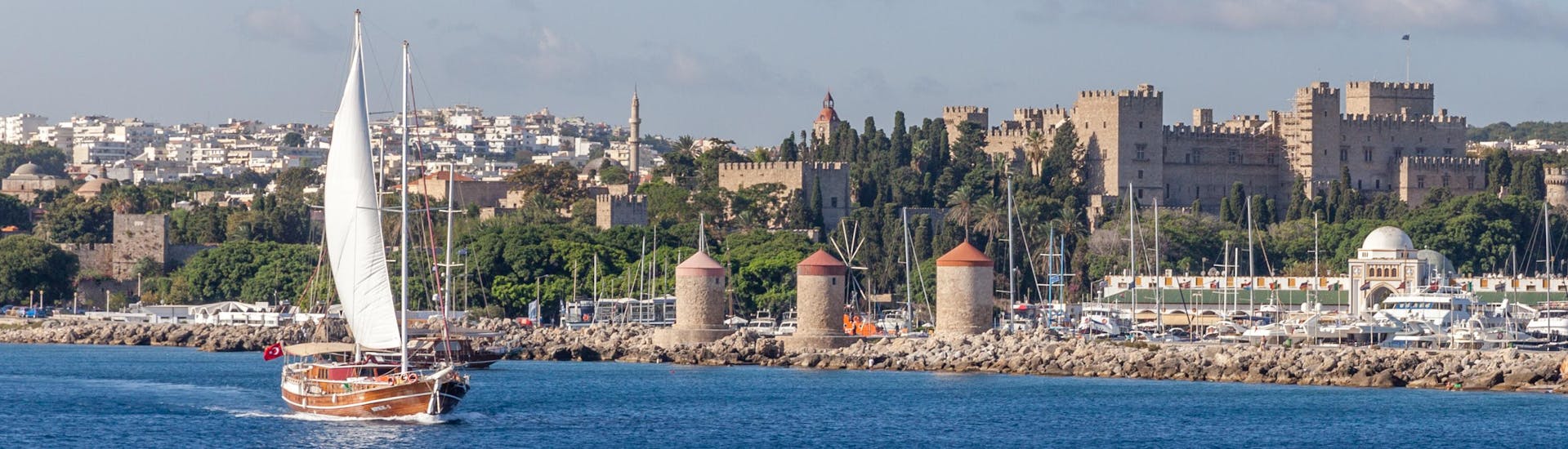 Plusieurs bateaux près du port de Mandraki avec la ville de Rhodes en arrière-plan.