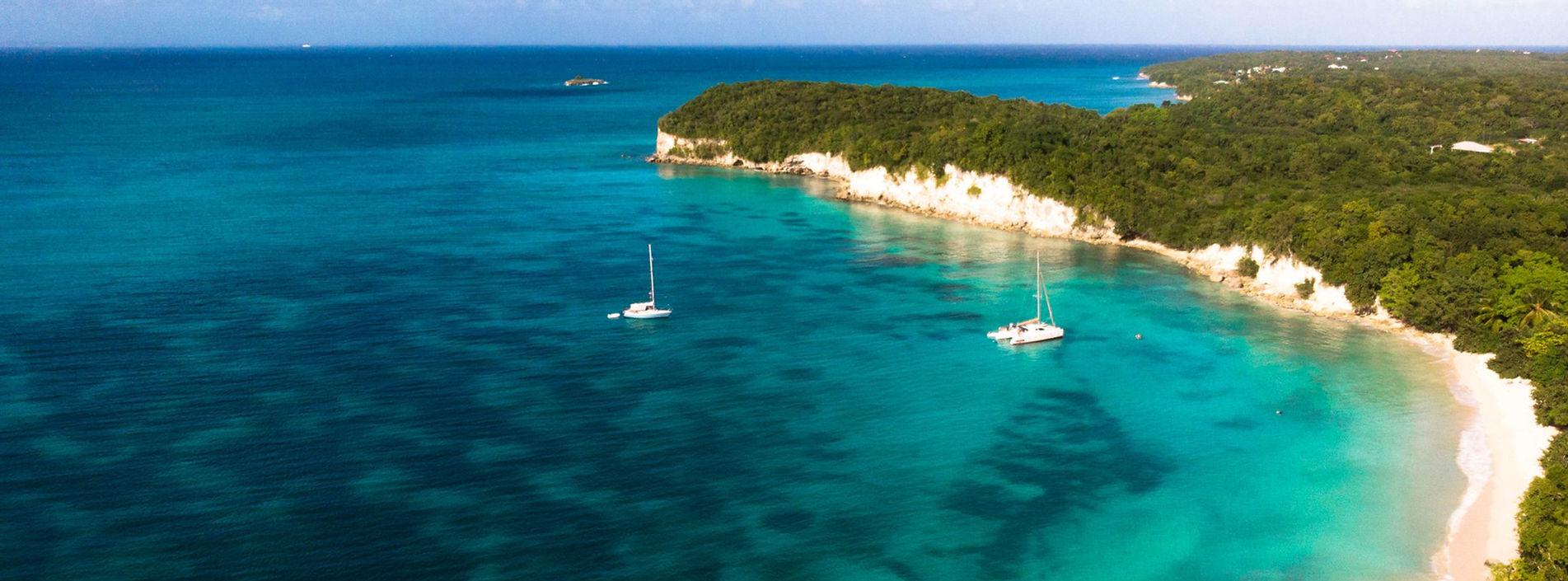 Dos catamaranes navegando en las aguas cristalinas a lo largo de la costa de Guadalupe con Manta Evasion.
