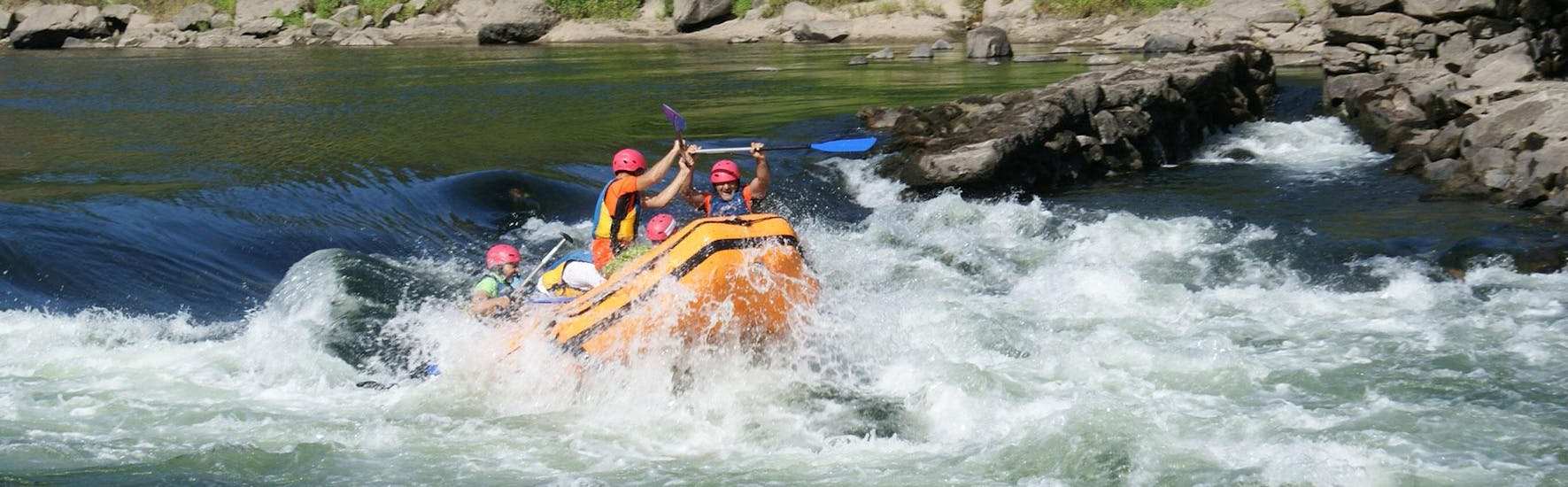 A group of people is attemting to keep the dinghy steady while rafting on the Minho River with Melgaço White Water.