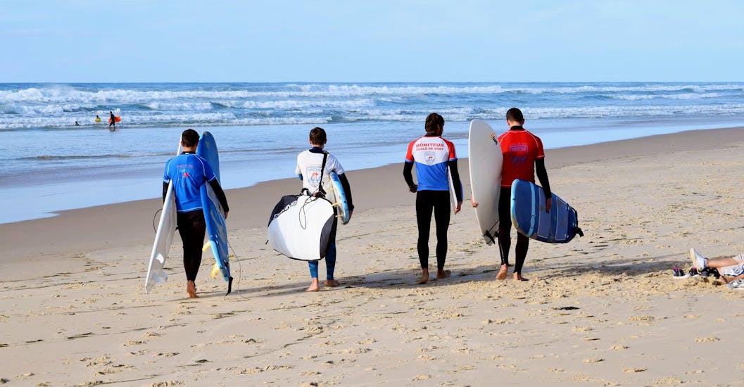 Des amis sur la plage de Mimizan pendant leurs cours de surf avec Mimizan Surf Academy.