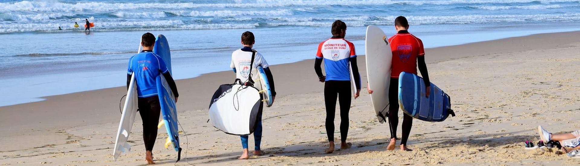 Des amis sur la plage de Mimizan pendant leurs cours de surf avec Mimizan Surf Academy.