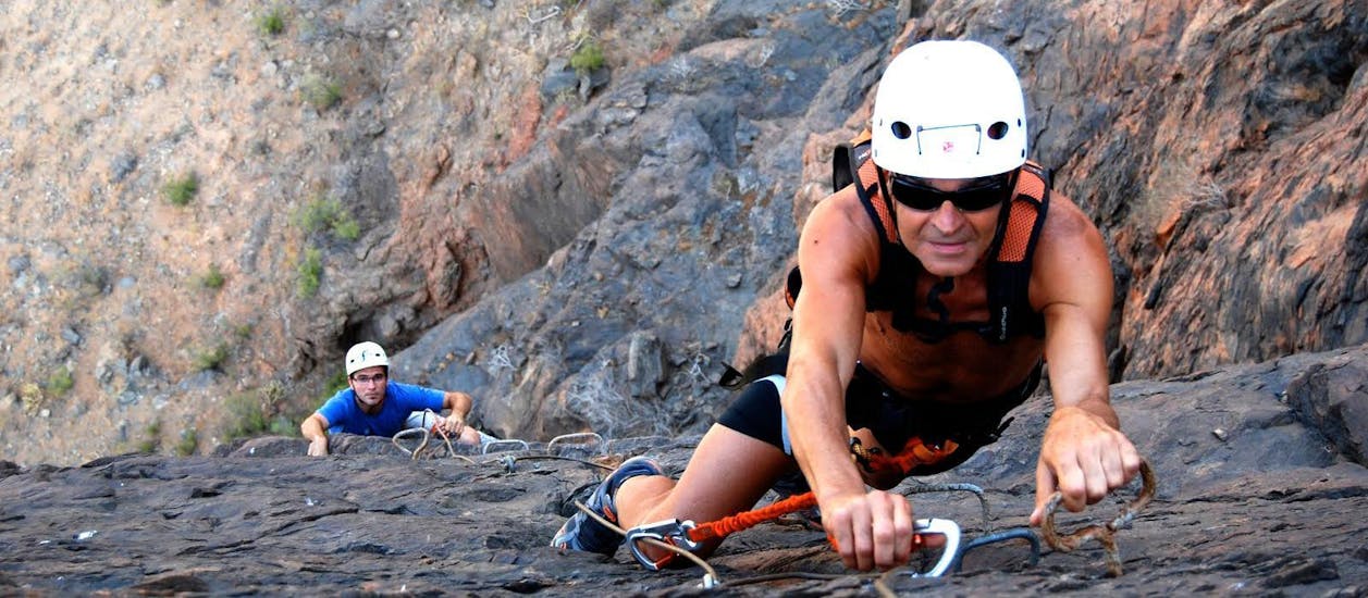 A man skilfully overcomes the obstacle during a via ferrata accompanied by Mojo Picón Aventura. 