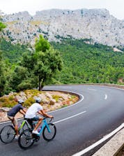 Dos jóvenes en la carretera con una hermosa vista haciendo ciclismo de montaña en Mallorca.