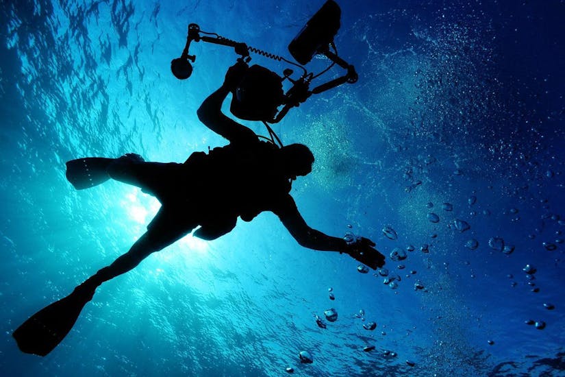 An local diving expert from Mykonos Diving Center,  swimming in the crystal clear water of the Aegean Sea in Mykonos.