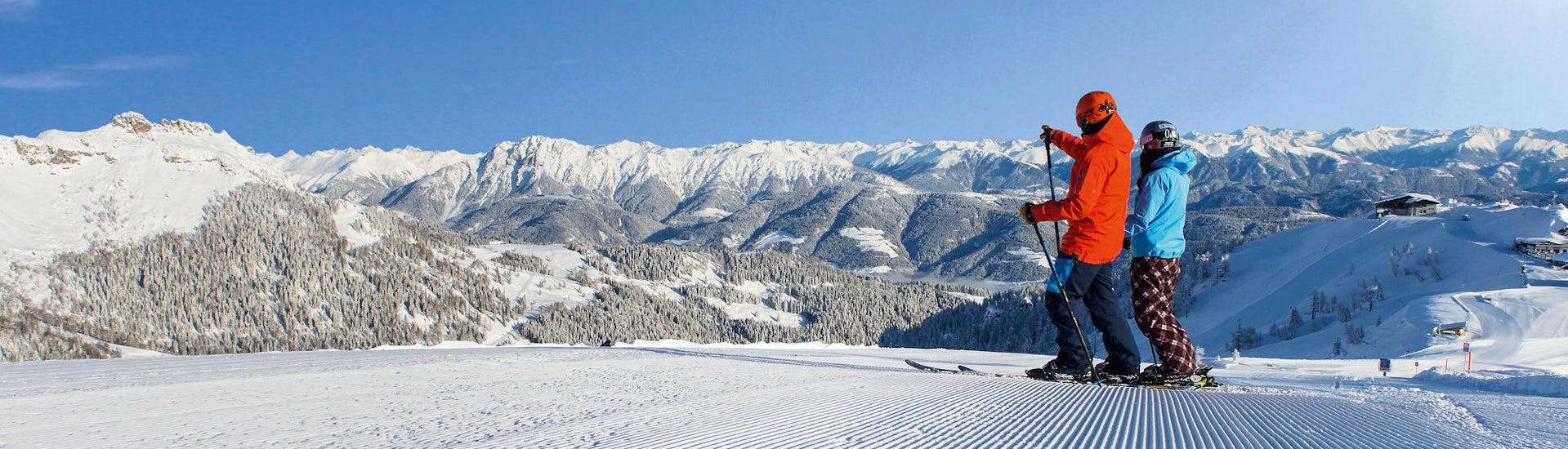Ausblick auf die sonnige Berglandschaft beim Skifahren lernen mit den Skischulen im Skigebiet Nassfeld-Pressegger See.