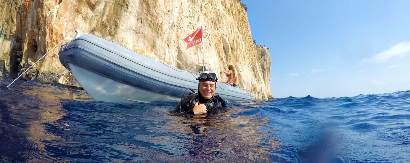 A man floats in the sea near the RIB after scuba diving along the Baunei coast with Nautica Sea Service Ogliastra.