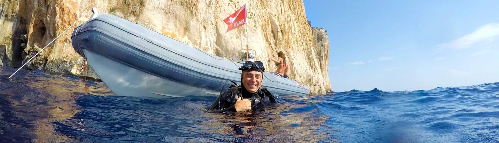 Un uomo galleggia in acqua nei pressi del gommone dopo le Immersioni sub nella costa di Baunei con Nautica Sea Service Ogliastra.