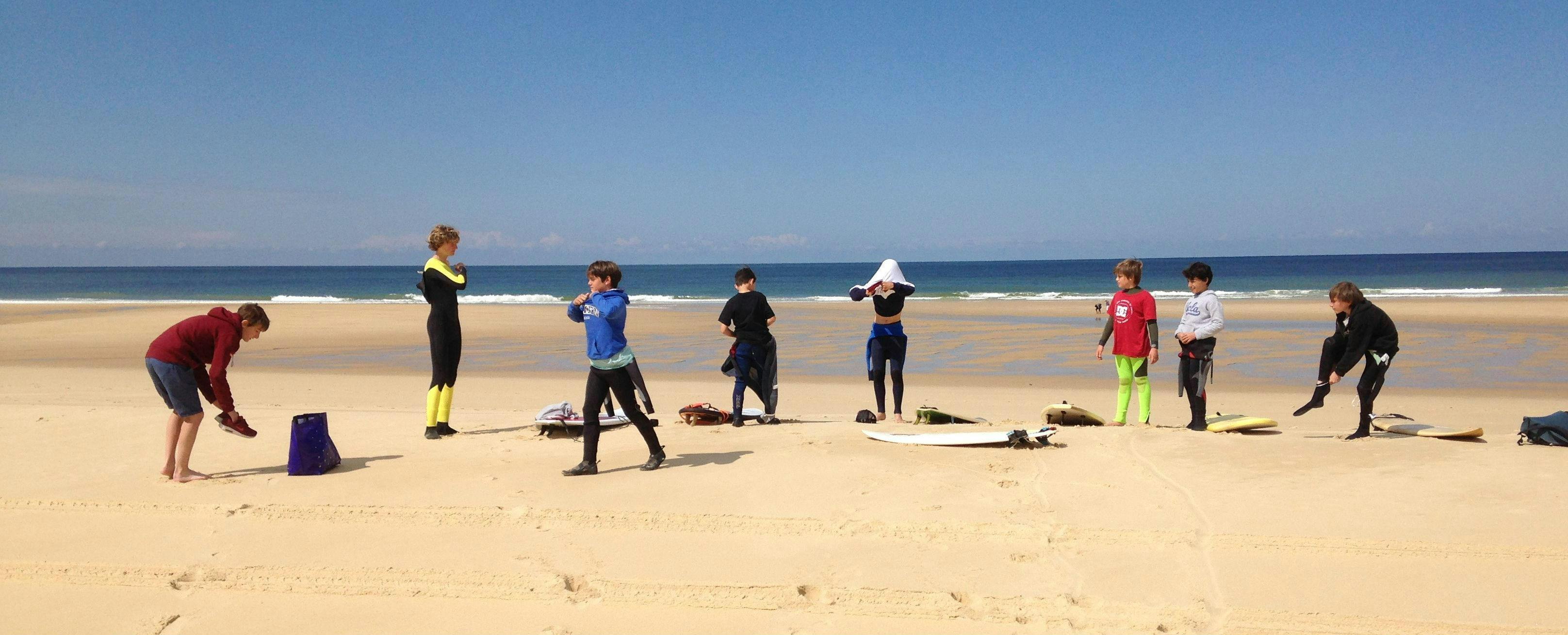 nomad-surf-school-hero children are having surfing lessons on the sail fish beach in Cap-Ferret with Nomad surf school.