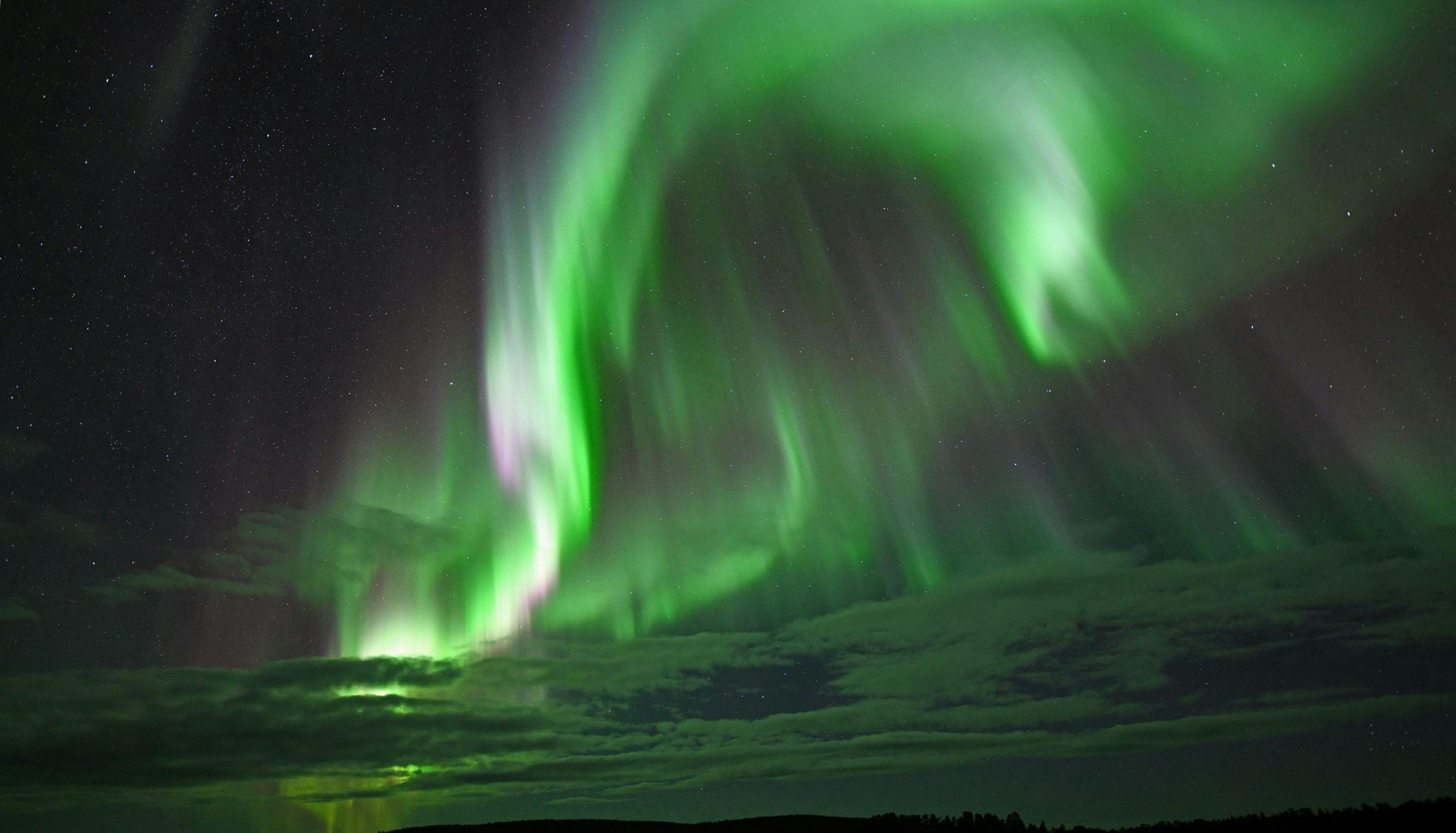 Northern Lights Riders Ivalo Des aurores boréales vertes et vives dansent dans le ciel étoilé au-dessus d'Ivalo.