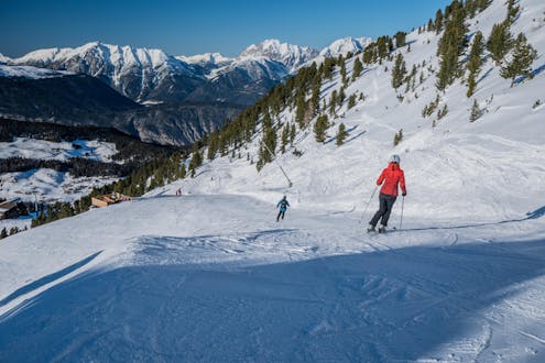 Adultos y niños esquiando en la estación de esquí de Oetz-Hochoetz.