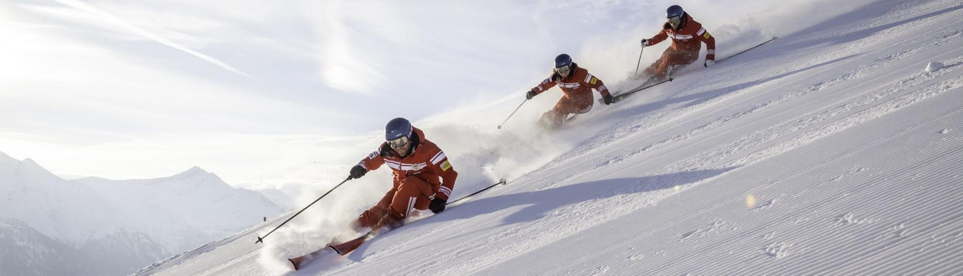 Drei Skifahrer der Official Swiss Ski School Rougemont Gstaad genießen eine Abfahrt während dem Skikurs.