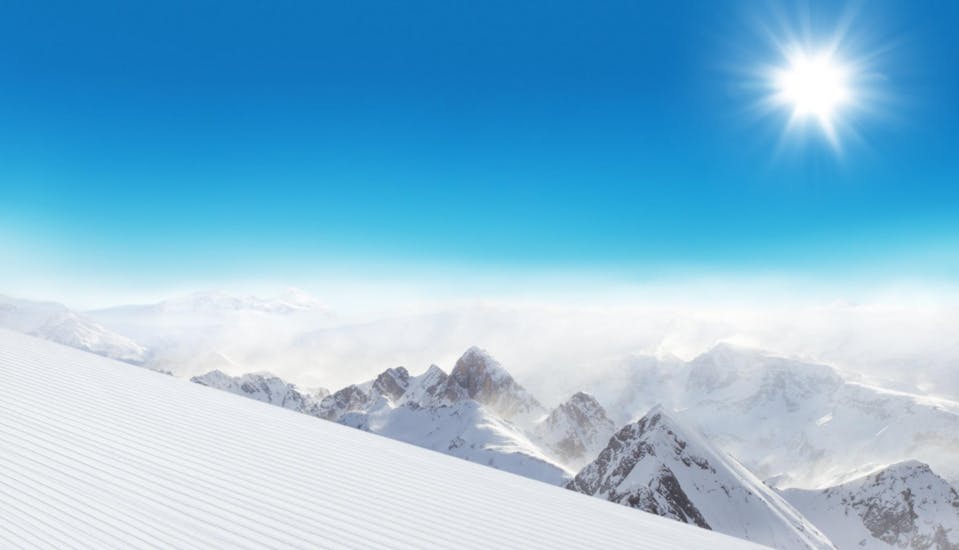 El impresionante paisaje invernal que se puede contemplar al hacer un Otras actividades a partir de 14 años para todos los niveles organizado por Skischule Schneider Events Geißkopf con cumbres nevadas y cielo azul sobre la niebla que cubre las montañas.